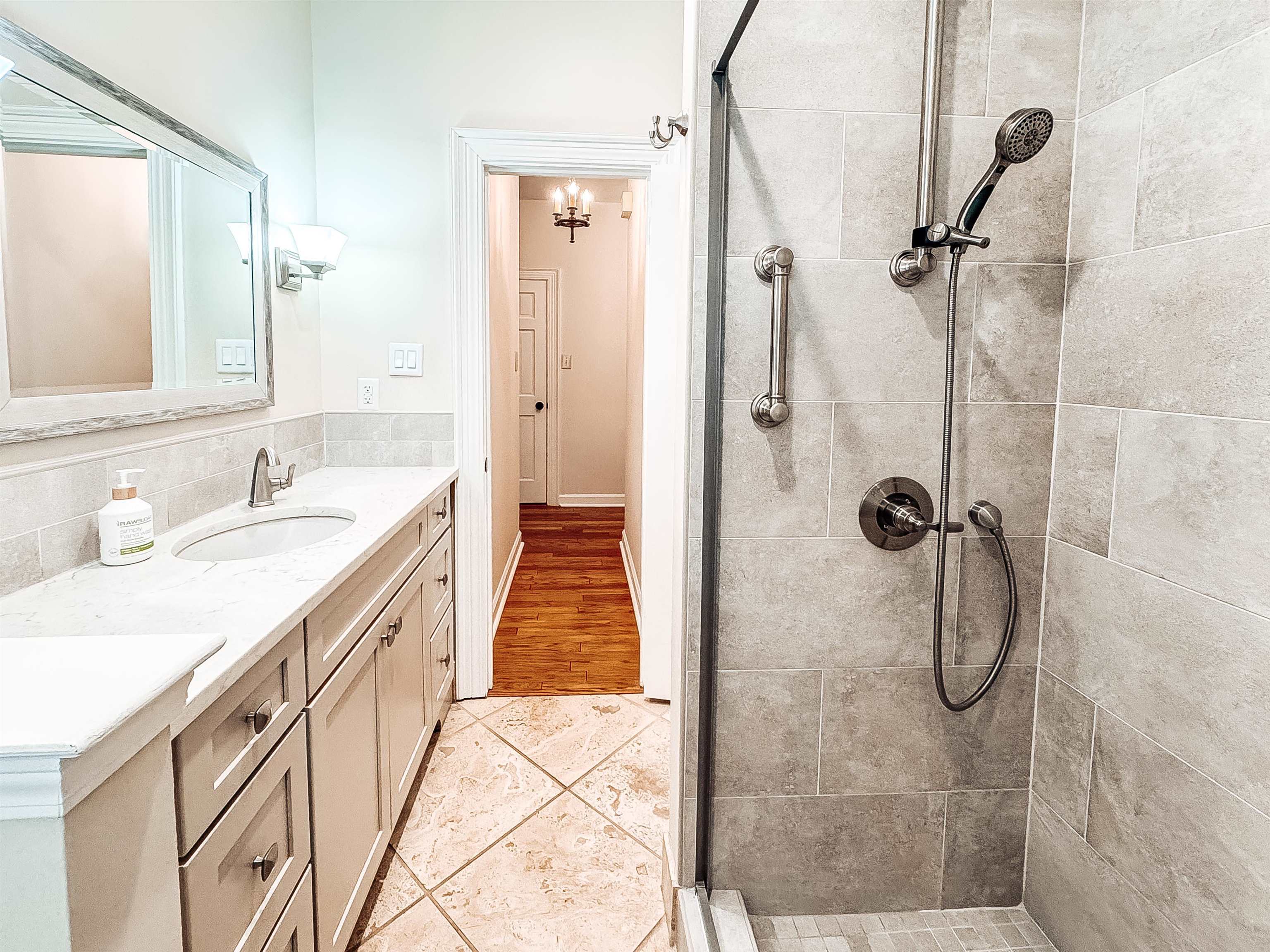 832 South Tree Drive Collierville, TN 38017 - Photo 22 of 40 Bathroom featuring a tiled walk-in shower with glass enclosure, a single vanity with a white countertop and undermount sink, and a framed mirror