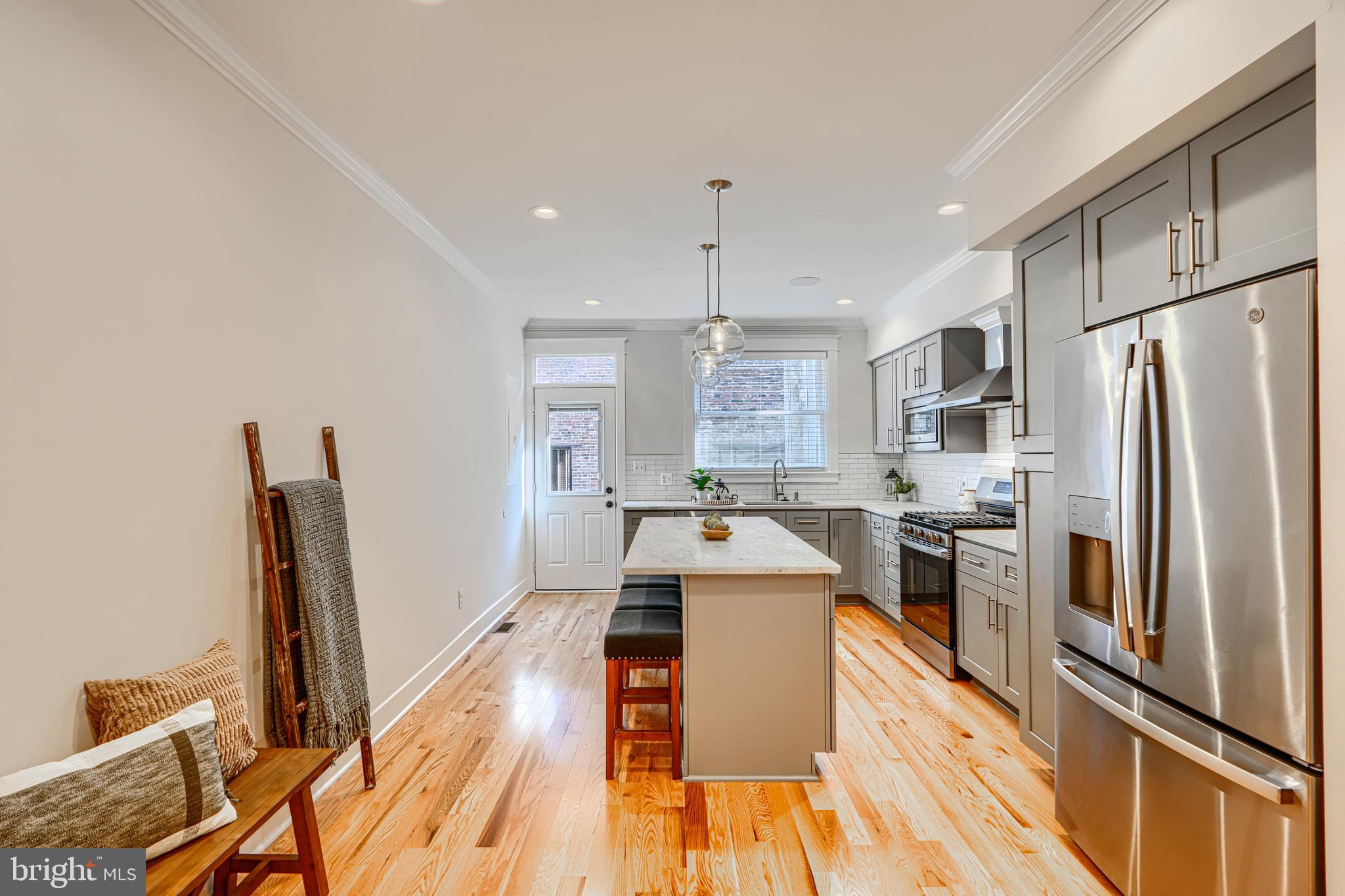 609 South Eaton Street Baltimore, MD 21224 - Photo 11 of 36 a large kitchen with stainless steel appliances a refrigerator a stove a sink dishwasher and a stove with wooden floor