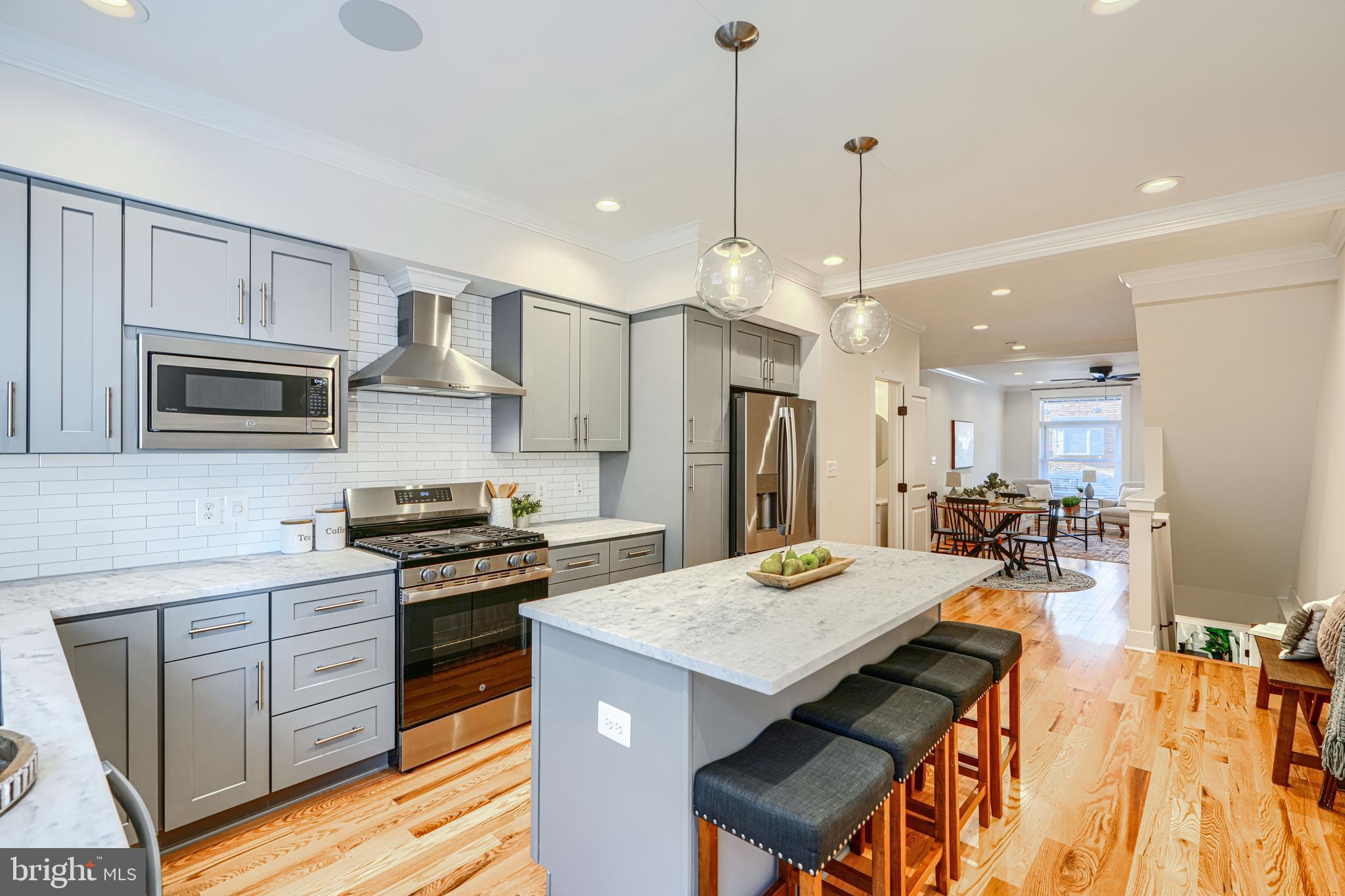 609 South Eaton Street Baltimore, MD 21224 - Photo 14 of 36 a kitchen with a refrigerator a stove top oven a sink dishwasher and white cabinets with wooden floor