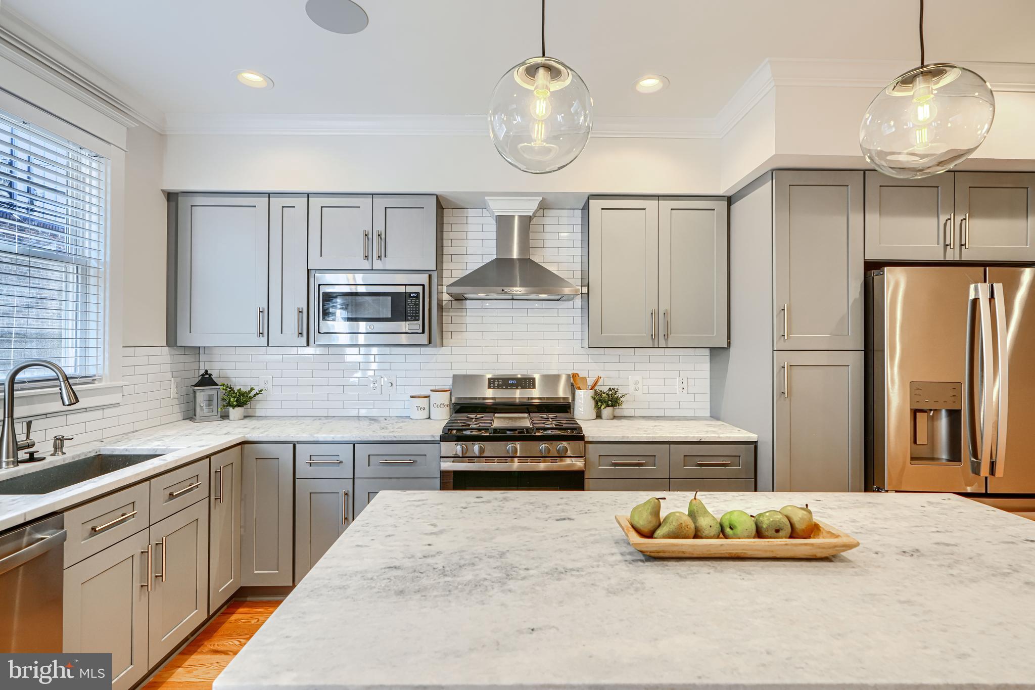 609 South Eaton Street Baltimore, MD 21224 - Photo 16 of 36 a kitchen with kitchen island stainless steel appliances a sink cabinets and wooden floor