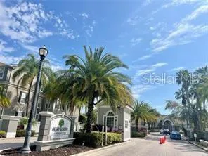 a view of multiple houses with a yard and palm trees