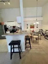 a kitchen with a sink a stove and chairs with wooden floor