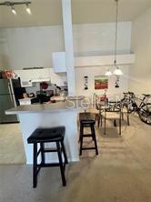 3325 South Kirkman Road, Unit 420 Orlando, FL 32811 - Photo 4 of 14 a kitchen with a sink a stove and chairs with wooden floor