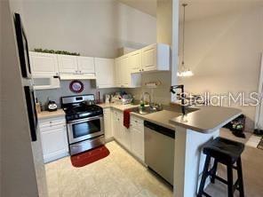 3325 South Kirkman Road, Unit 420 Orlando, FL 32811 - Photo 5 of 14 a kitchen with stainless steel appliances a stove a sink and a refrigerator