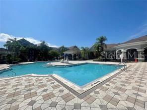 3325 South Kirkman Road, Unit 420 Orlando, FL 32811 - Photo 7 of 14 a view of swimming pool with outdoor seating and a garden