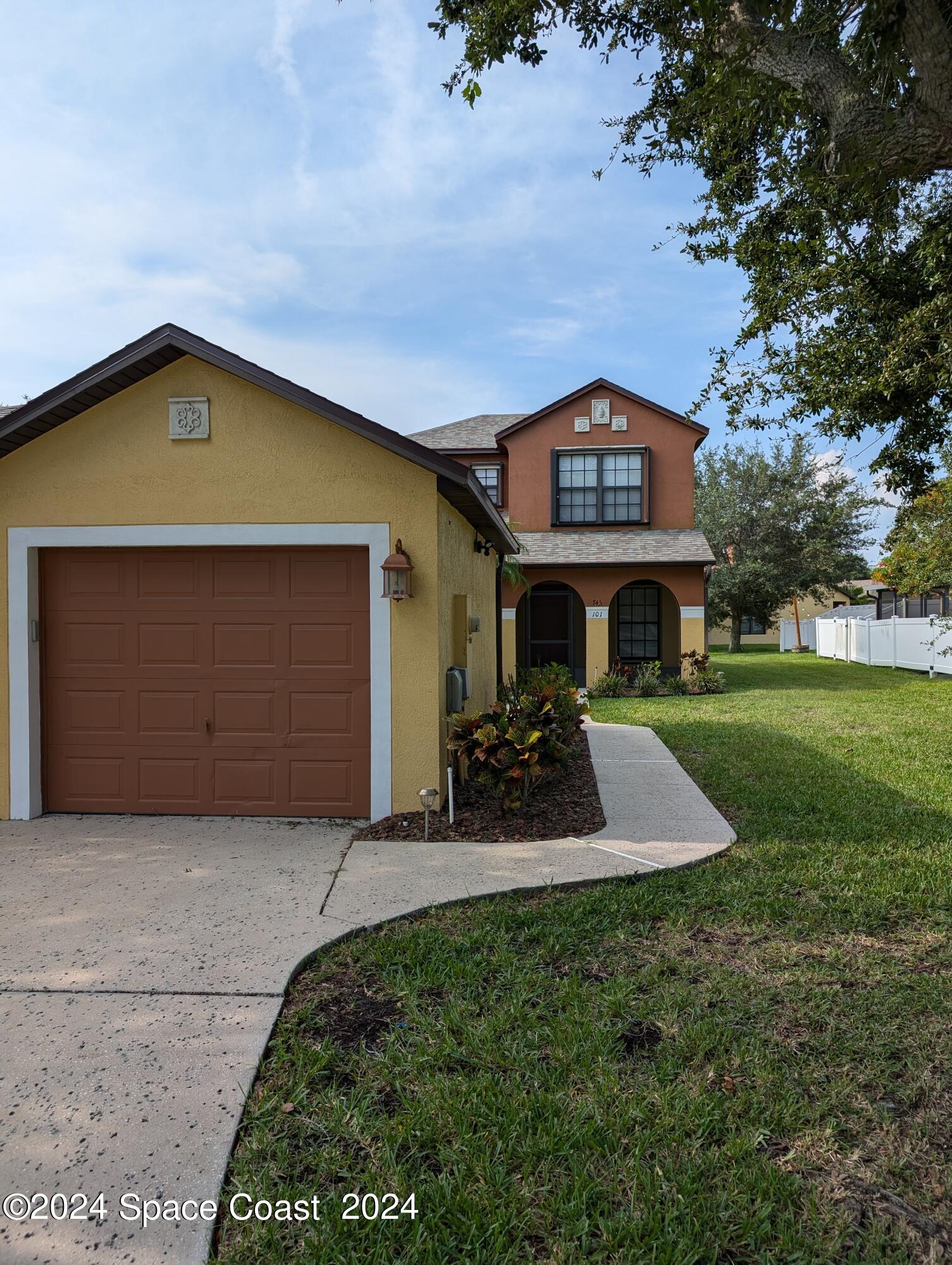 745 Luminary Circle, Unit 101 Melbourne, FL 32901 - Photo 2 of 32 a front view of a house with a yard