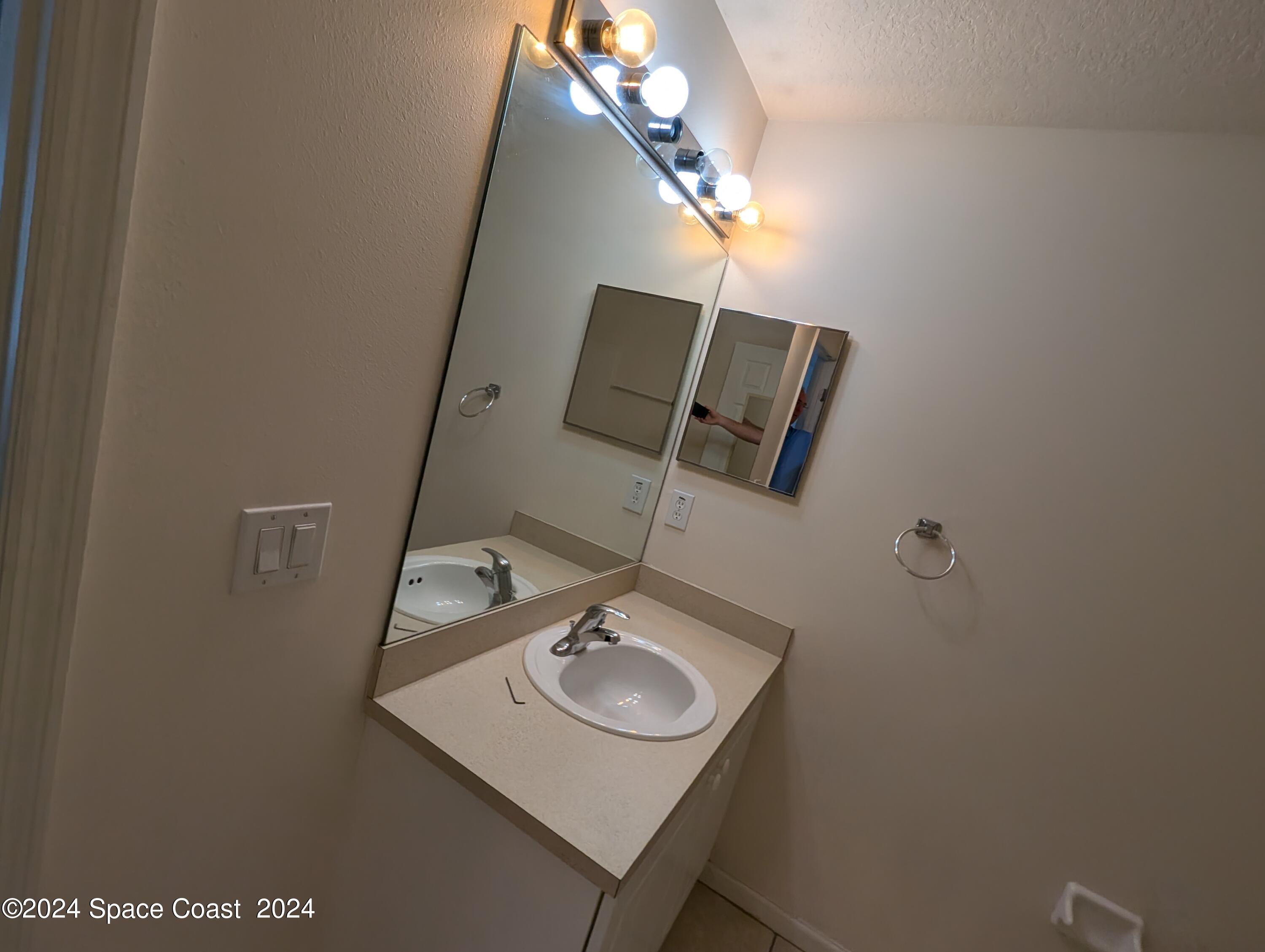 745 Luminary Circle, Unit 101 Melbourne, FL 32901 - Photo 23 of 32 a bathroom with a sink and mirror