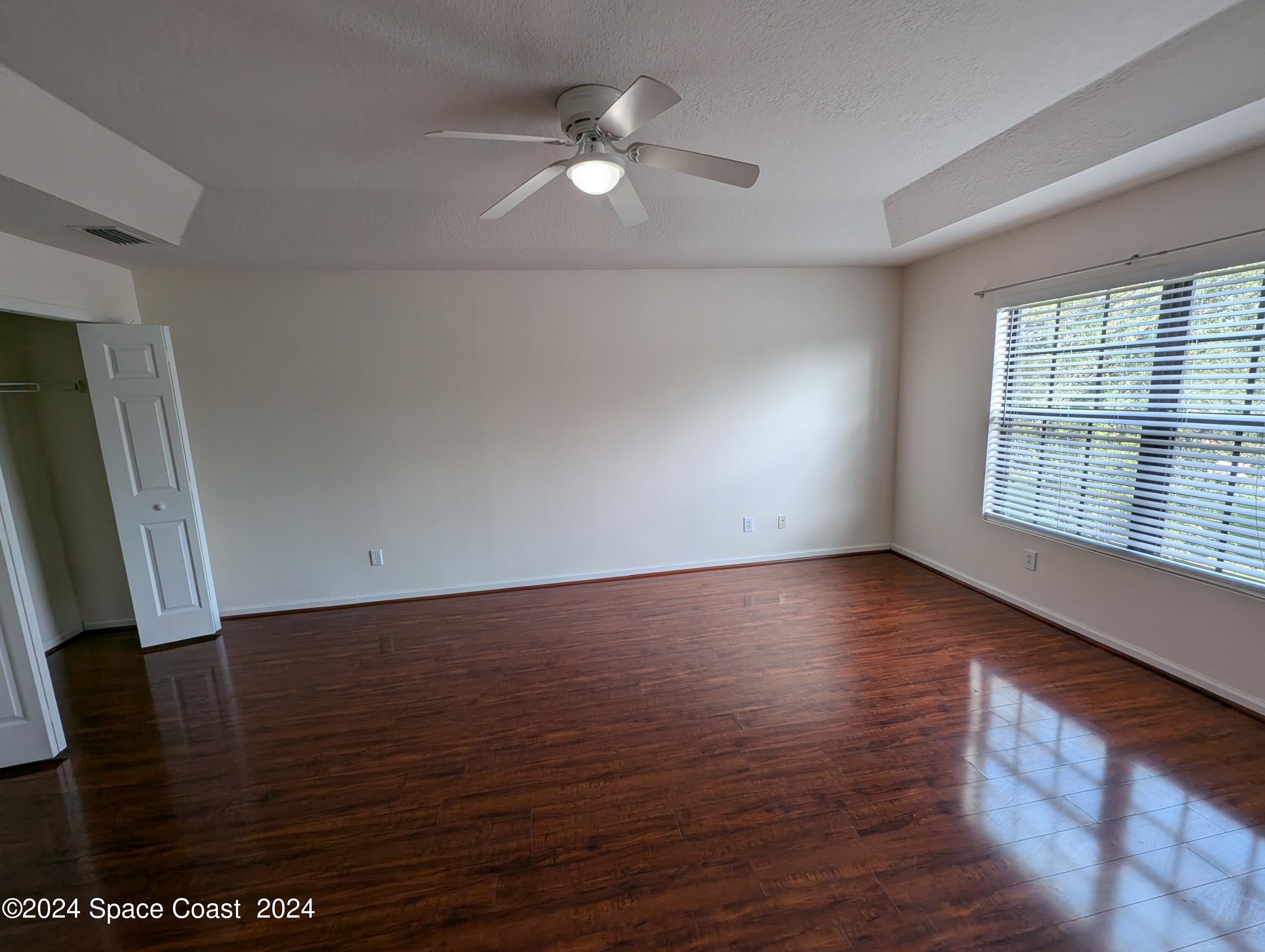 745 Luminary Circle, Unit 101 Melbourne, FL 32901 - Photo 24 of 32 an empty room with wooden floor and windows