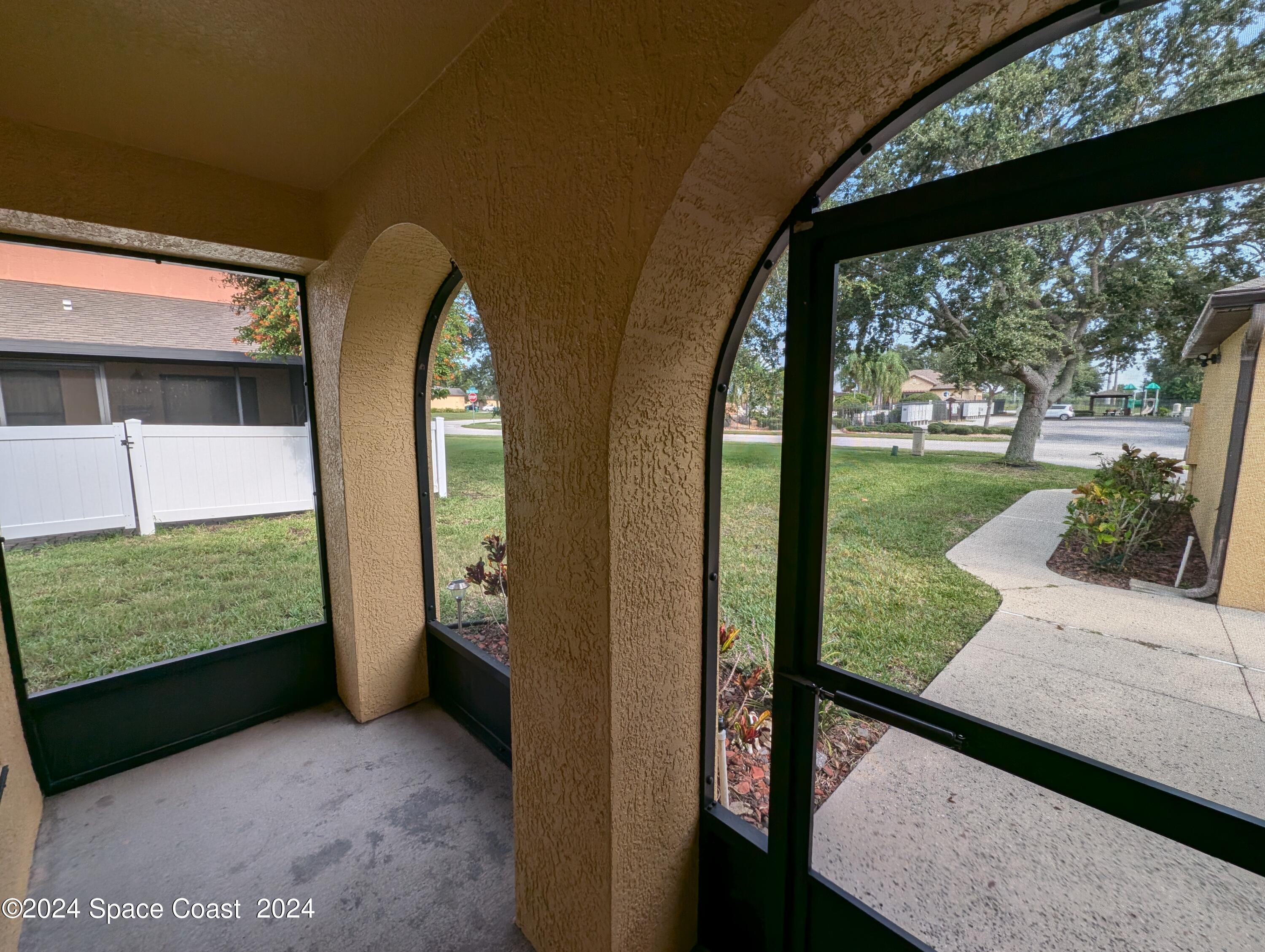 745 Luminary Circle, Unit 101 Melbourne, FL 32901 - Photo 26 of 32 a view of a porch with a floor to ceiling window next to a yard