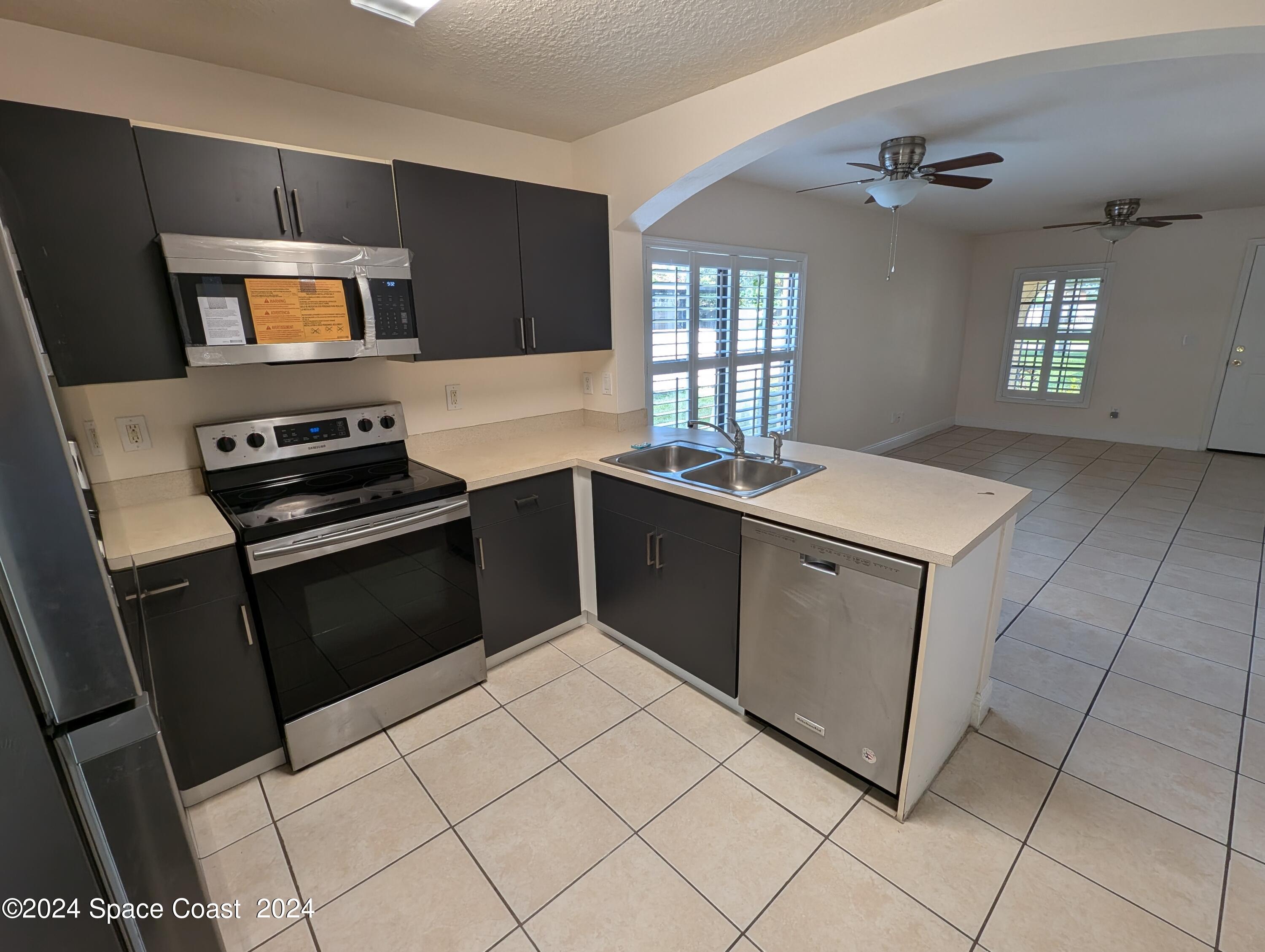 745 Luminary Circle, Unit 101 Melbourne, FL 32901 - Photo 4 of 32 a kitchen with a sink stove and microwave