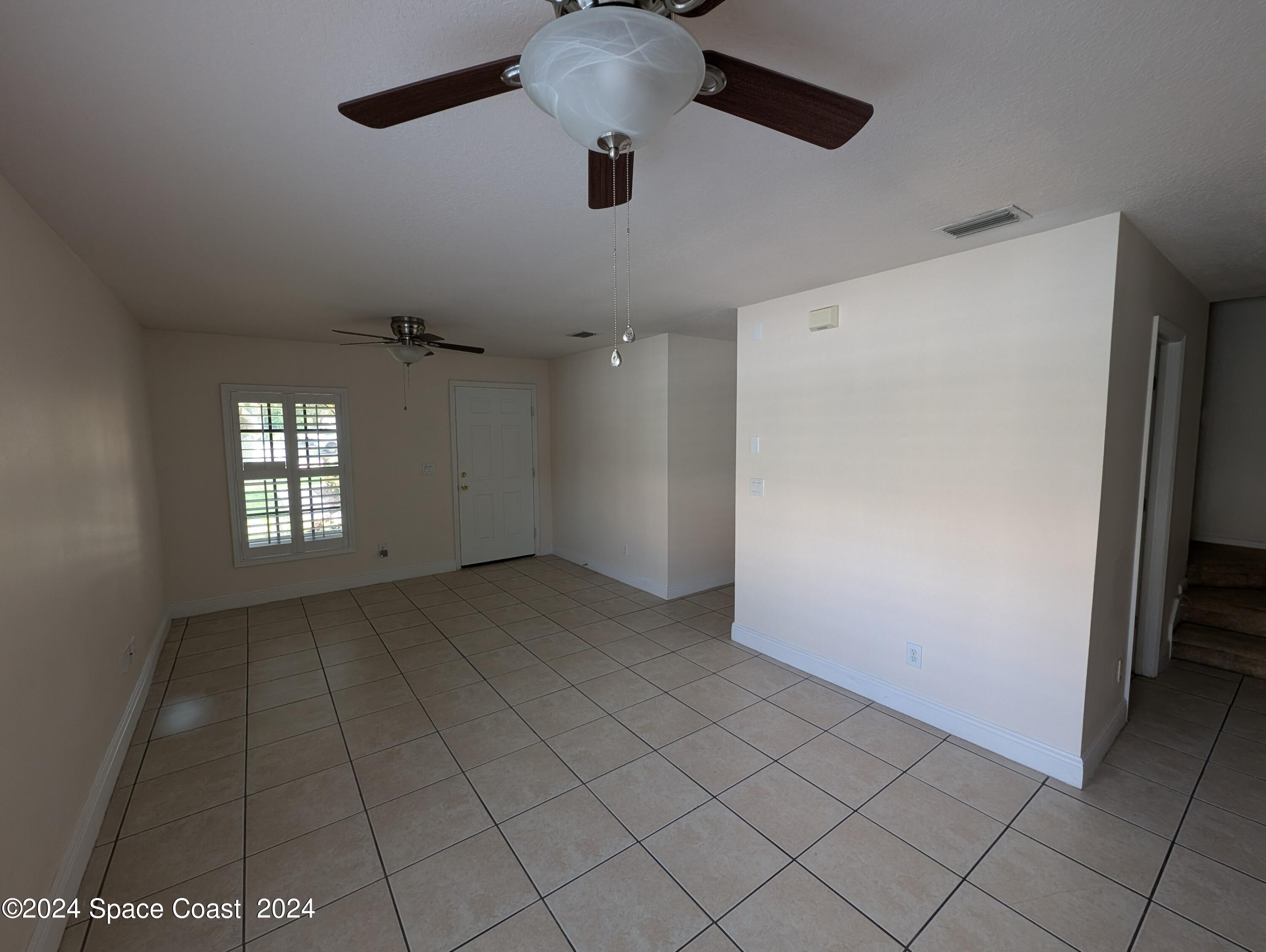745 Luminary Circle, Unit 101 Melbourne, FL 32901 - Photo 8 of 32 an empty room with windows and fan