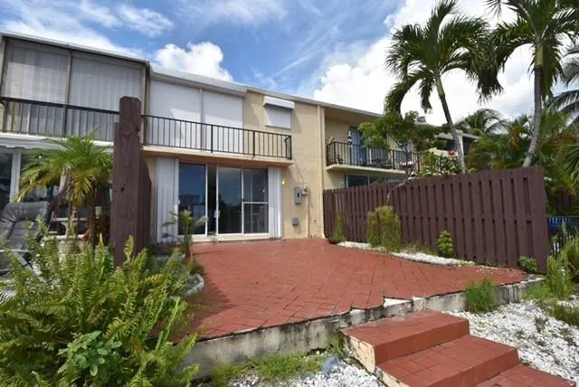 a front view of a house with a yard and potted plants