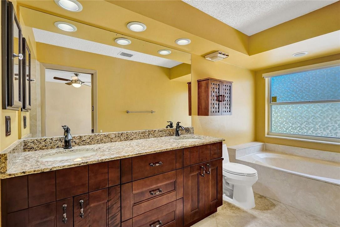 10576 Plainview Circle Boca Raton, FL 33498 - Photo 23 of 51 a bathroom with a granite countertop sink toilet and mirror