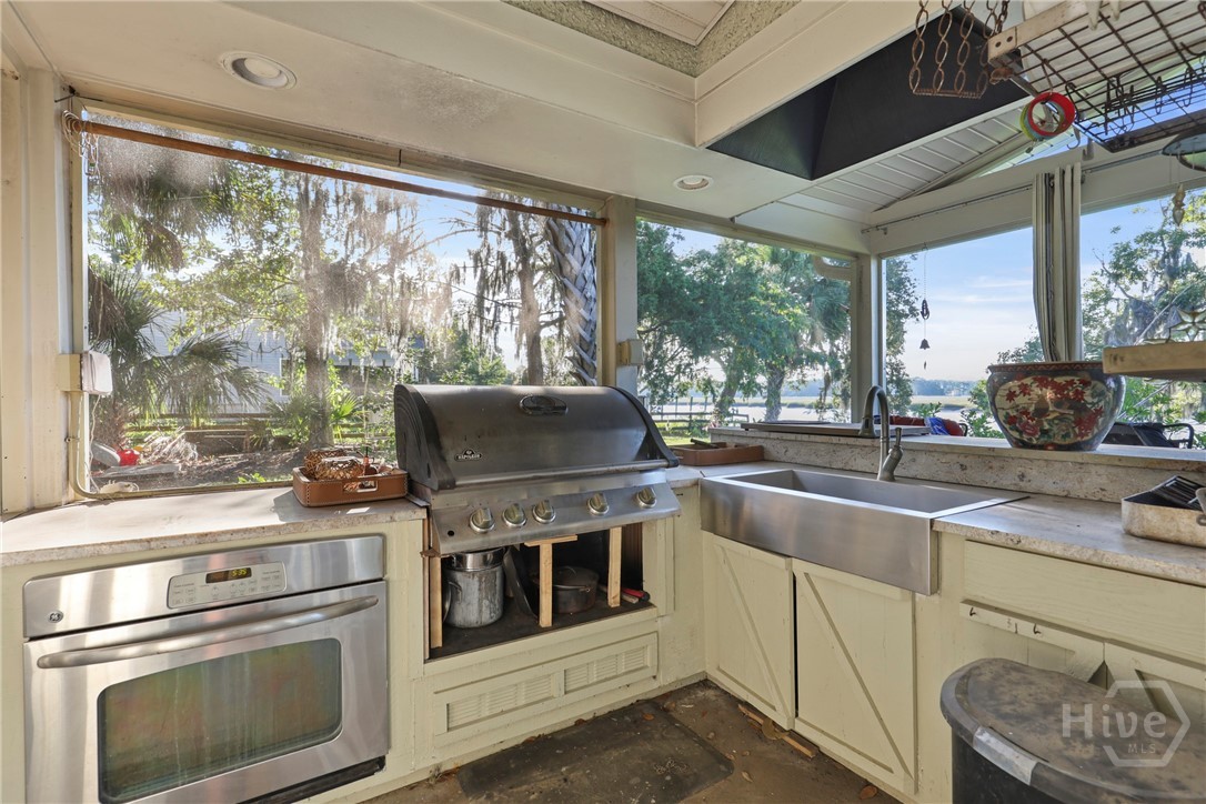 189 East 1st Street Midway, GA 31320 - Photo 20 of 50 Outdoor kitchen with oven, grille and stainless steel farmhouse sink.