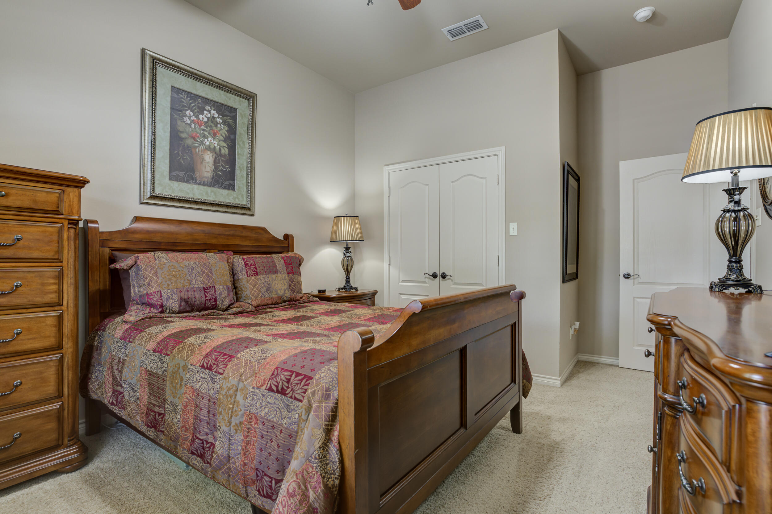6008 89th Street Lubbock, TX 79424 - Photo 44 of 61 a bedroom with a bed and a lamp on dresser
