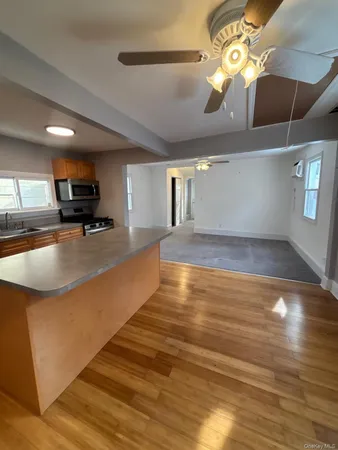 a kitchen with stainless steel appliances granite countertop a sink a stove and a wooden floors