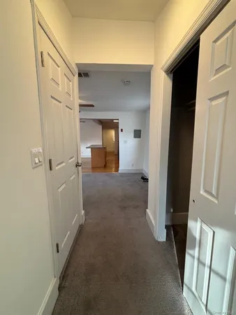 a view of a hallway with wooden shelves