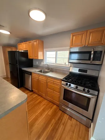 a kitchen with stainless steel appliances a stove a sink and a refrigerator