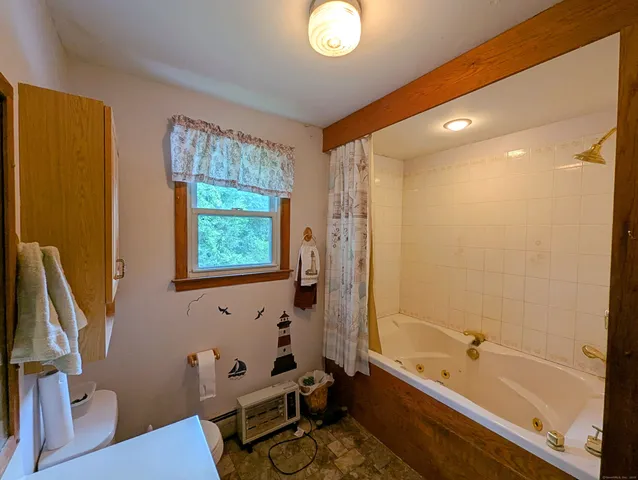 a bathroom with a tub a sink and a window