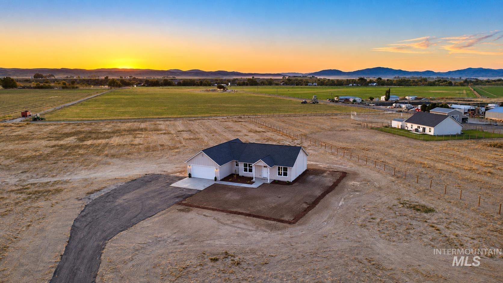 1371 Hansen Road Weiser, ID 83672 - Photo 41 of 44 Single-story residence with a two-car garage, dark shingle roof, and white siding