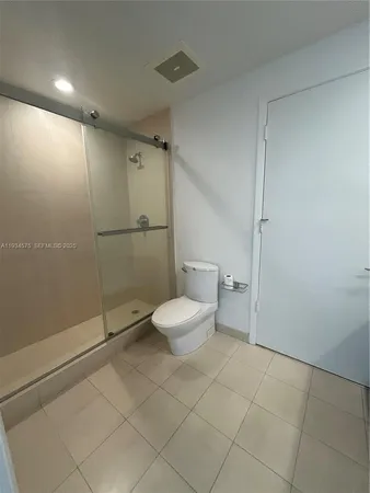 a bathroom with a granite countertop toilet and a shower