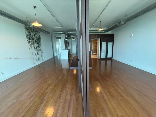 a view of a hallway with wooden floor