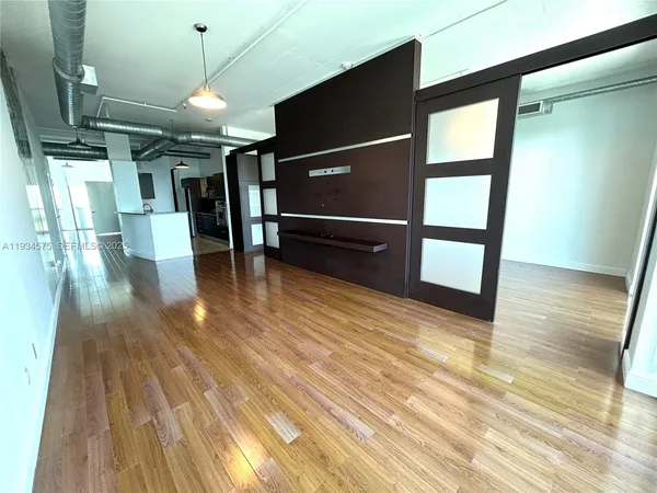 a view of empty room with wooden floor