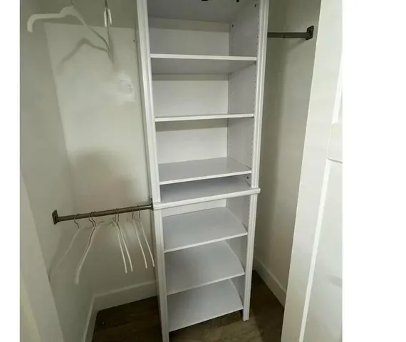 a view of walk in closet with empty racks
