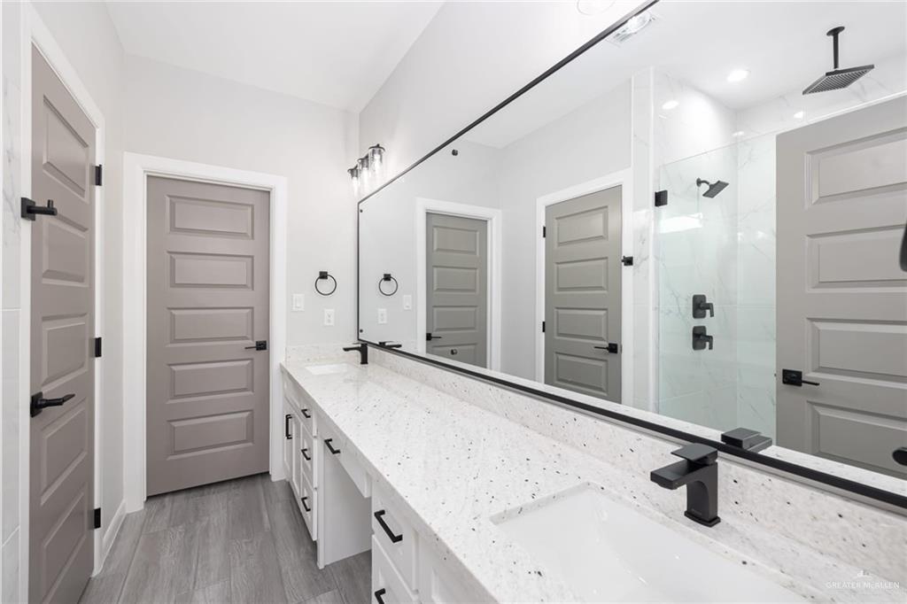 7710 Navel Lane Mission, TX 78574 - Photo 13 of 20 a bathroom with a granite countertop sink a mirror and a shower