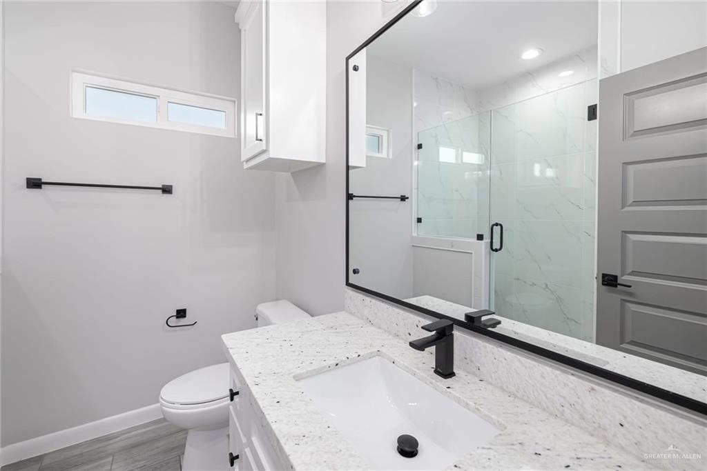 7710 Navel Lane Mission, TX 78574 - Photo 16 of 20 a bathroom with a sink a toilet and a mirror