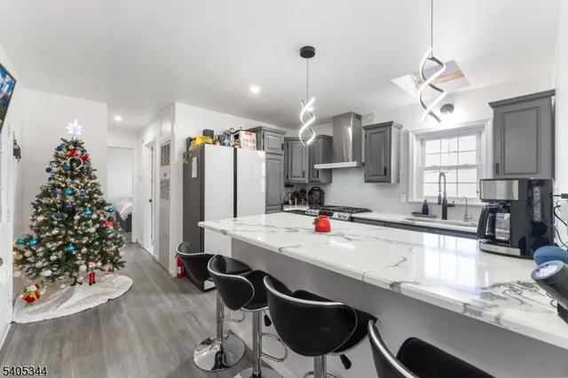 a kitchen with granite countertop a dining table chairs sink refrigerator and microwave