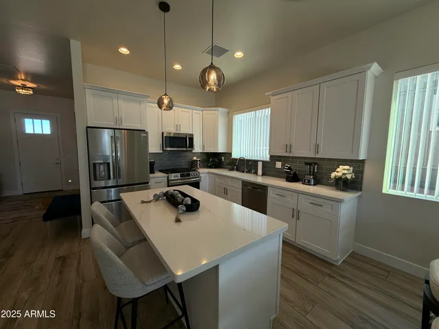 a kitchen with a sink a kitchen island and stainless steel appliances