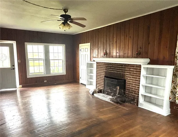 a view of an empty room with a fireplace and a window