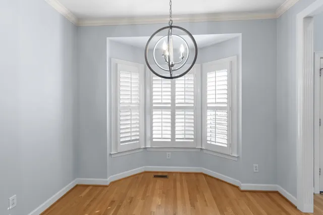 a view of wooden floor chandelier and window in a room