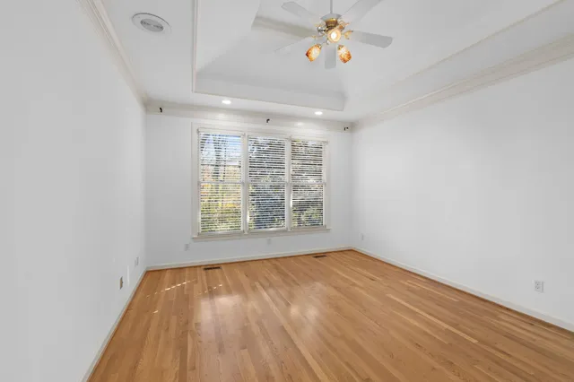 a view of an empty room with a window and wooden floor