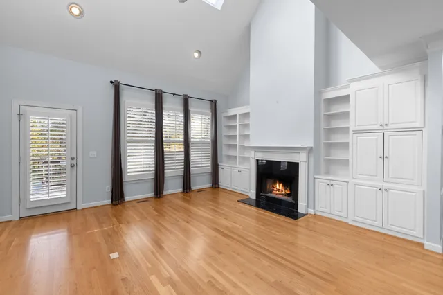 an empty room with windows and fireplace