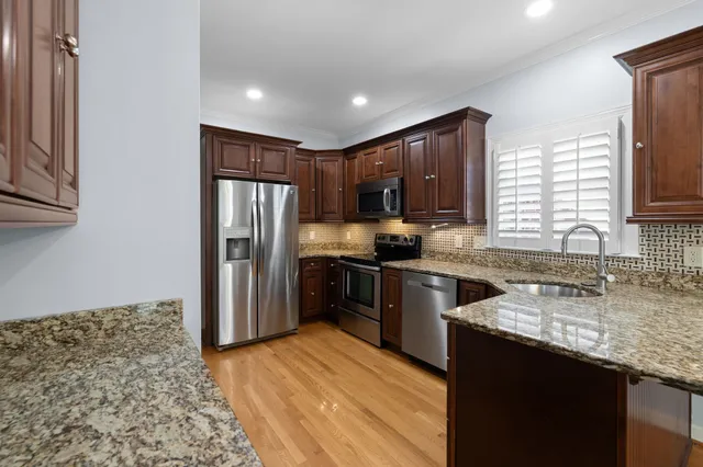 a kitchen with granite countertop stainless steel appliances and wooden cabinets