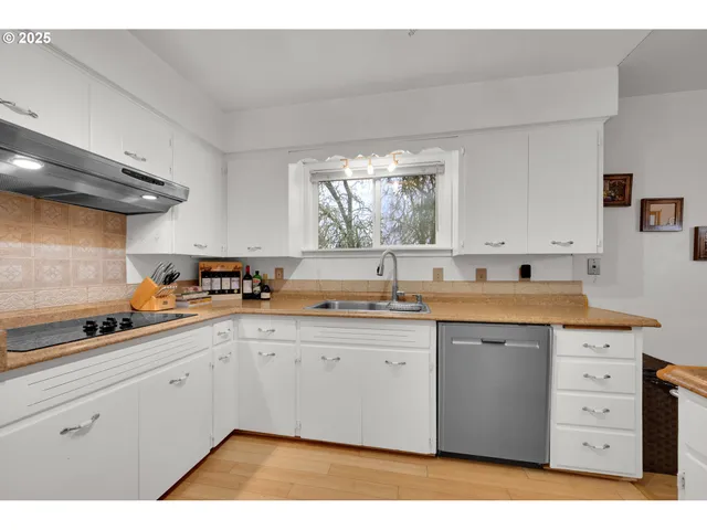 a kitchen with a sink window and cabinets
