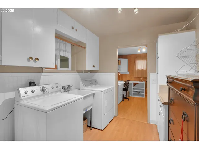 a utility room with cabinets washer and dryer