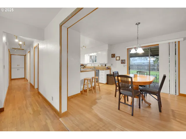a dining room with furniture a chandelier and wooden floor