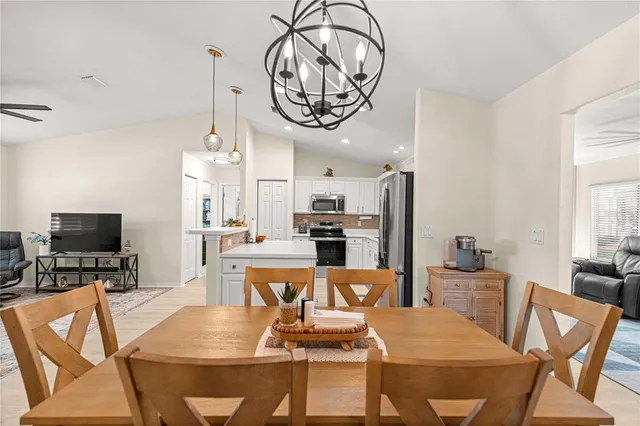 a view of a dining room with furniture a chandelier and wooden floor