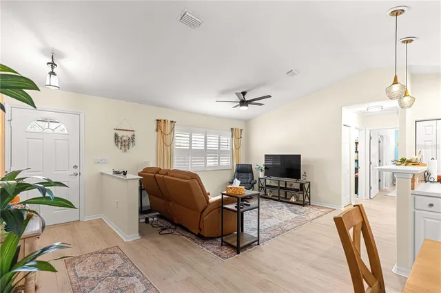 a living room with furniture a chandelier and a flat screen tv