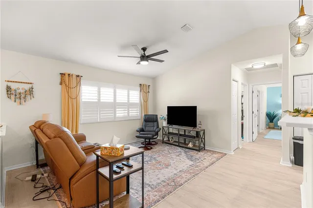 a living room with furniture a flat screen tv and a large window