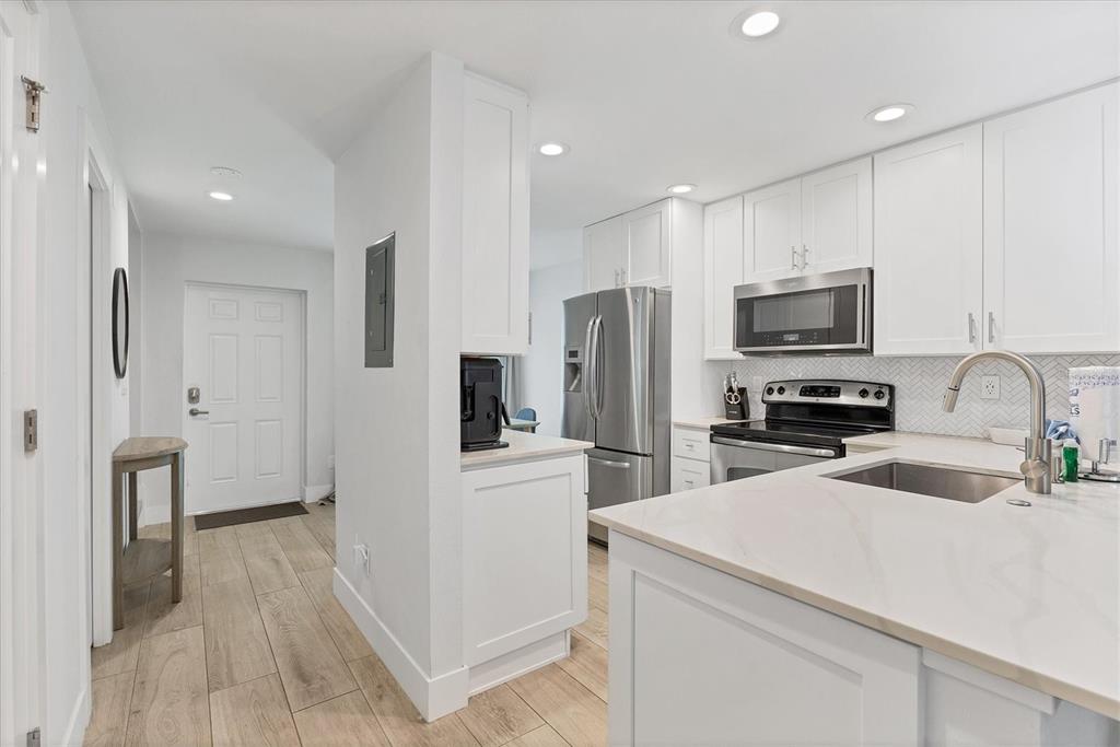 1762 Stickney Point Road, Unit 204 Sarasota, FL 34231 - Photo 12 of 38 a kitchen with a refrigerator stove and sink