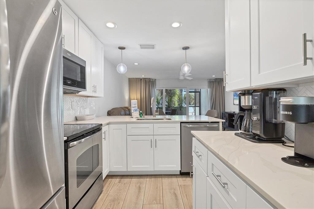 1762 Stickney Point Road, Unit 204 Sarasota, FL 34231 - Photo 14 of 38 a kitchen with a sink stove and cabinets