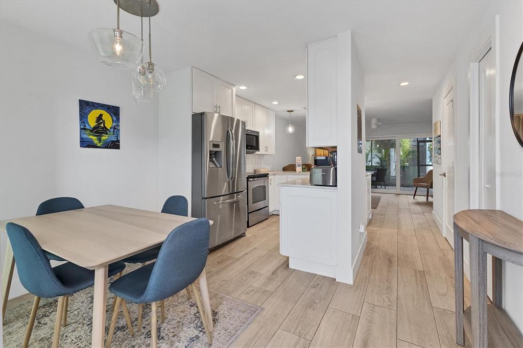 1762 Stickney Point Road, Unit 204 Sarasota, FL 34231 - Photo 16 of 38 a kitchen with stainless steel appliances kitchen island granite countertop a refrigerator and a wooden cabinets
