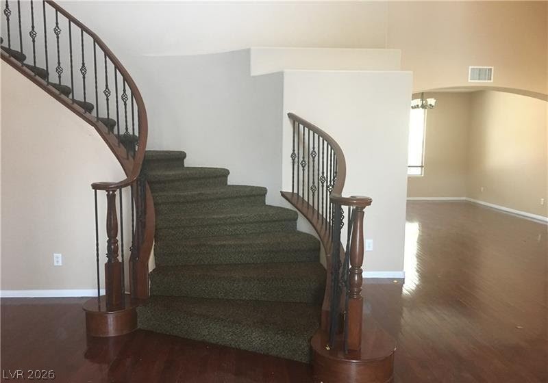 7414 Page Ranch Court Las Vegas, NV 89131 - Photo 8 of 36 Staircase with wood finished floors, arched walkways, and a chandelier