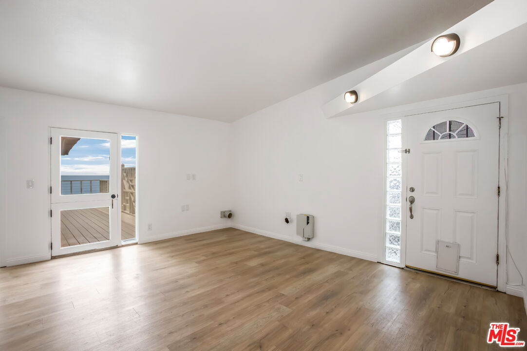 20644 Pacific Coast Highway Malibu, CA 90265 - Photo 12 of 32 an empty room with wooden floor & windows and bathroom
