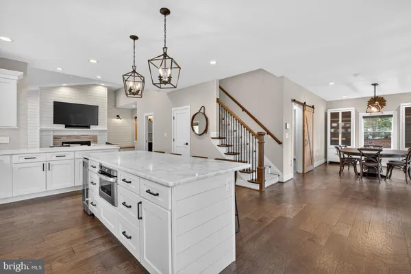 a open kitchen with white cabinets and chandelier