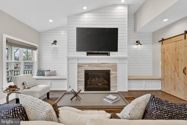 a living room with furniture a flat screen tv and a fireplace